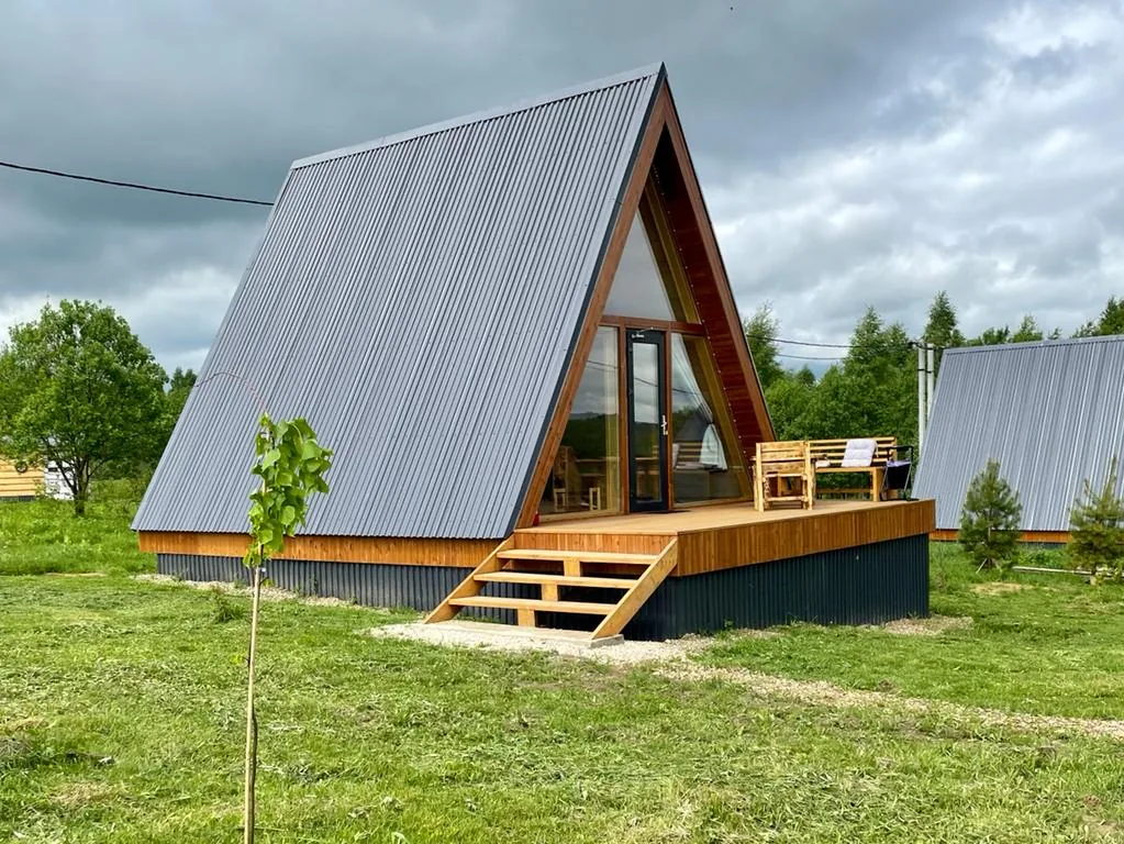A-frame домик «Мелисса» фито-отеля «Лаванда» на лугу, вокруг открытое пространство